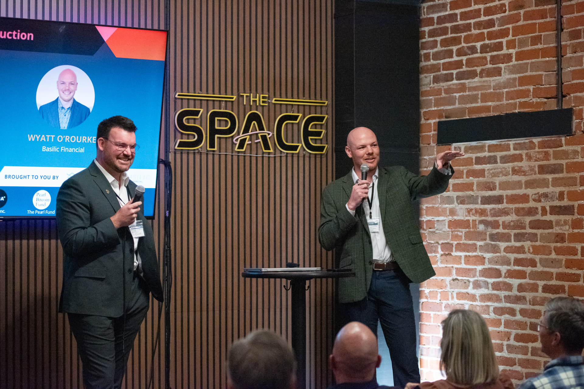 Two speakers with microphones presenting on stage at the summit